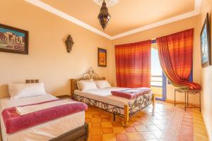 a bedroom with two beds and a window at arganier solitaire in Souira Guedima +15 photos