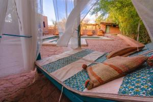 Ckoi Atacama Lodge في سان بيدرو دي أتاكاما: سرير في خيمة مع إطلالة على حمام السباحة +139 صورة