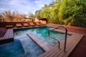 Ckoi Atacama Lodge في سان بيدرو دي أتاكاما: مسبح مع كراسي