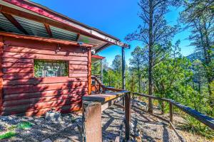 una baita nel bosco con una staccionata di legno e delle scale di Mountain Top Cabin with a View - Bear Cabin a Ruidoso Altre 19 foto
