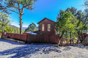 una piccola casa con una recinzione di fronte di Mountain Top Cabin with a View - Bear Cabin a Ruidoso