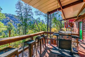 a porch with a stove and stools on a deck at Mountain Top Cabin with a View - Bear Cabin in Ruidoso +22 photos