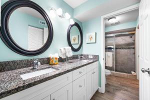 een badkamer met een wastafel en een spiegel bij Blue Ocean Suites by Beachside Management in Siesta Key +92 foto's