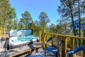 una vasca idromassaggio seduta su una terrazza con sedia di Mountain Top Cabin with a View - Bear Cabin a Ruidoso