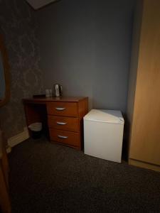 a small bathroom with a dresser and a white toilet at Piccolo Guest House in Glasgow