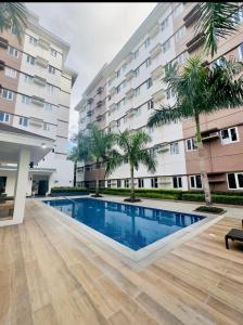 G-VibeZzz Staycation في Trece Martires: حمام سباحة أمام مبنى