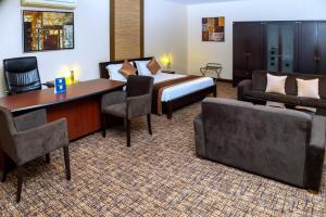 Una habitación de hotel con una cama, un escritorio y sillas. en Hotel 33 Kampala, en Kampala