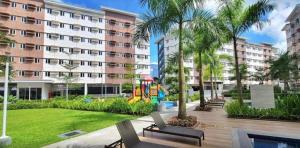 G-VibeZzz Staycation في Trece Martires: مجمع سكني به ملعب وأشجار نخيل