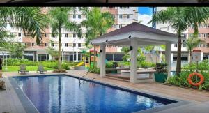 G-VibeZzz Staycation في Trece Martires: مسبح مع شرفة بجانب مبنى +10 صور