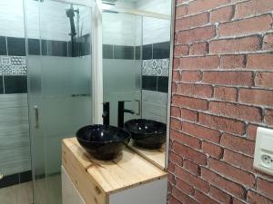 a bathroom with two sinks on a counter with a brick wall at Nid cozy au Lioran in Le Lioran +12 photos