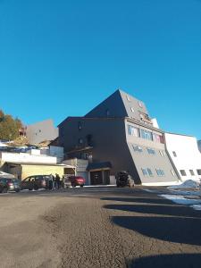 a large building with cars parked in a parking lot at Nid cozy au Lioran in Le Lioran