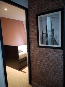 a mirror on a brick wall in a bedroom at Nid cozy au Lioran in Le Lioran