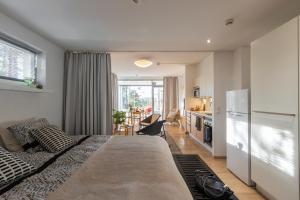 a bedroom with a large bed and a kitchen at RUF studio Naantali- Unique design apartment in Naantali