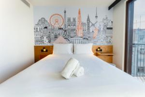 a bedroom with a large white bed with a large window at easyHotel Valencia Ciutat Vella in Valencia