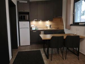 a kitchen with a wooden table and a white refrigerator at Rác Relax in Rácalmás
