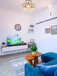 a living room with blue furniture and a flat screen tv at Five-Eight Residences in Jinja +85 photos