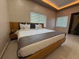 ein Schlafzimmer mit einem großen Bett mit weißen Laken und Kissen in der Unterkunft Hotel The Devaraj in Bhubaneshwar