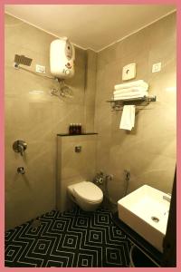 Un baño con un inodoro blanco y un lavabo. en Sea Shell Residency, en Puri