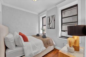 a white bedroom with a bed and a window at Gramercy Apartment - 3BR 2BA Modern Central in New York