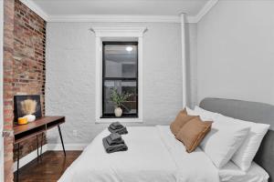 a white bed in a room with a window at Gramercy Apartment - 3BR 2BA Modern Central in New York