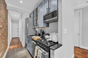 a kitchen with a stove and a microwave at Gramercy Apartment - 3BR 2BA Modern Central in New York +30 photos