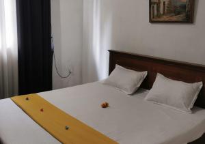 una cama con cabecero de madera y dos almohadas en S And K Holiday Stay, en Beruwala