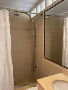 eine Dusche im Bad mit einem Spiegel und einem Waschbecken in der Unterkunft Casa amoblada 6 personas in Coquimbo