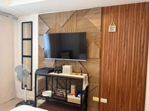 a living room with a television on a wooden wall at New Studio Boho Studio with PS4 & Balcony in San Fernando