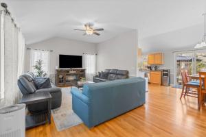 een woonkamer met een blauwe bank en een tv bij Cape Cod Family Getaway Hot Tub Firepit in West Hyannisport