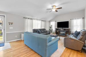 een woonkamer met een blauwe bank en een tv bij Cape Cod Family Getaway Hot Tub Firepit in West Hyannisport