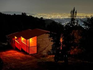 Una pequeña cabaña con luces rojas por la noche. en La Cabaña, en Tlazala de Fabela