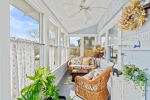 een afgeschermde veranda met een stoel en ramen bij Cape Cod Bungalow Walk to Beach Firepit in Hyannis