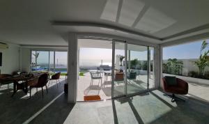 ein Wohnzimmer mit Glastüren, einem Tisch und Stühlen in der Unterkunft Villa Encantada Costa Adeje in Adeje