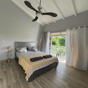a bedroom with a bed with a ceiling fan at La Retraite Apt in Rodney Bay Village