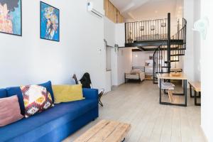 a living room with a blue couch and a staircase at Vintage duplex with jacuzzi in Málaga