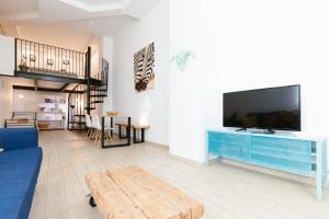 a living room with a blue couch and a tv at Vintage duplex with jacuzzi in Málaga