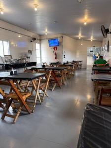 a row of tables and chairs in a room at Pacheco Pousada in Sabará