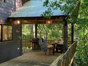 Cabaña Bosque Río في بوكون: سطح خشبي عليه شواية وطاولة