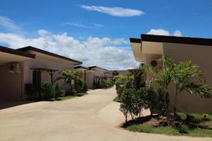 a row of houses with palm trees and a driveway at On Green Resort in Ban Huai Sua