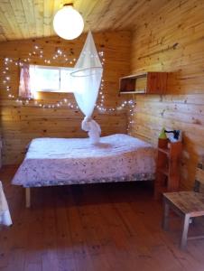 a bedroom with a bed in a log cabin at Chalets rustiques en pleine nature, L'ARCHIPEL in Punta Del Diablo