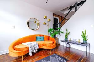 un sofá naranja en una sala de estar con mesa en Urban Jungle by Jungle House 5 800 Reviews Downtown & Short North Steps to High Street Close to OSU Convention Center & Nationwide Arena Free Parking, en Milo 52 fotos más