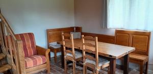Un comedor con mesa y sillas de madera. en Gîte la petite maison, en Pontchardon 25 fotos más