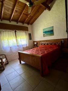 Un dormitorio con una cama grande con un edredón rojo. en Casa Quinta El Refugio, en Villa Gesell