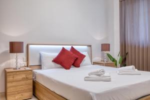 a bedroom with a large white bed with red pillows at Cozy 1 Bedroom Maisonette near Ta Xbiex Marina in Taʼ Xbiex