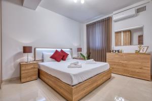 a bedroom with a large bed with red pillows at Cozy 1 Bedroom Maisonette near Ta Xbiex Marina in Taʼ Xbiex +19 photos