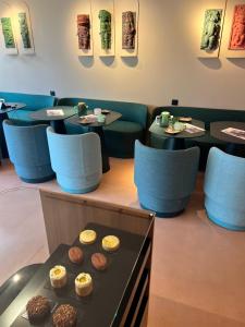 a restaurant with tables and chairs with donuts on a table at Yatt Hotel in Arcachon +28 photos