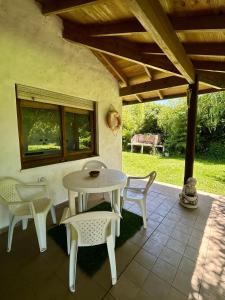 un patio con mesa y sillas bajo un techo en Casa Quinta El Refugio, en Villa Gesell 20 fotos más