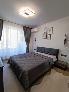 a bedroom with a large bed and a large window at Boutique apartment 4 in Plovdiv