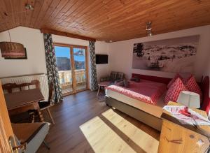 a living room with a bed and a balcony at Almhaus Bachmann in Sonnenalpe Nassfeld