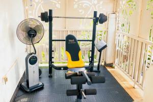 a room with a gym with a fan and a chair at Mirembe Villas Kigo in Kigo